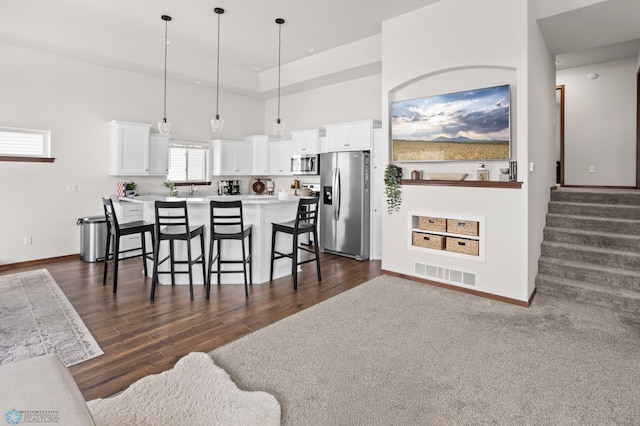 1592 69th Ave S, Fargo, ND 58104 - kitchen featuring appliances with stainless steel finishes, a kitchen breakfast bar, white cabinets, decorative light fixtures, and light countertops