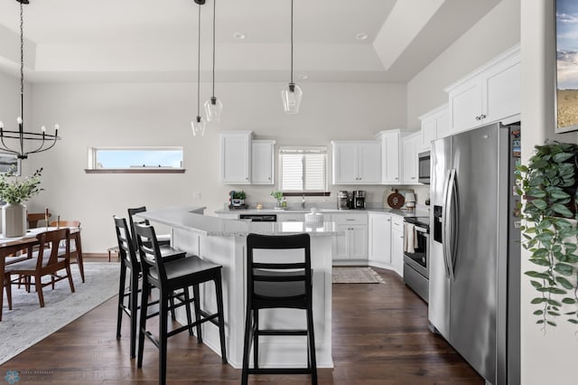1592 69th Ave S, Fargo, ND 58104 - kitchen with appliances with stainless steel finishes, a center island, a chandelier, a breakfast bar area, and white cabinetry