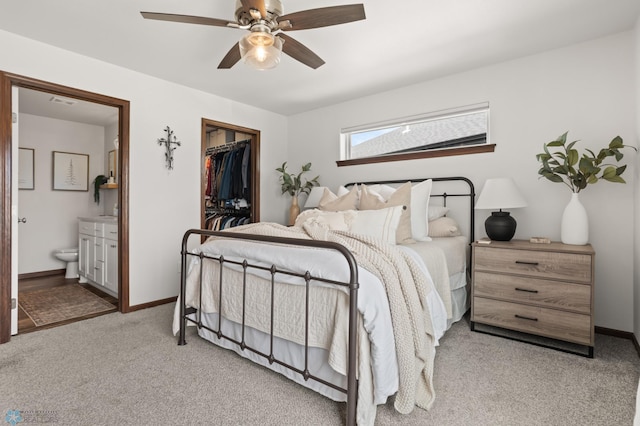 1592 69th Ave S, Fargo, ND 58104 - bedroom featuring light carpet, connected bathroom, a spacious closet, and ceiling fan