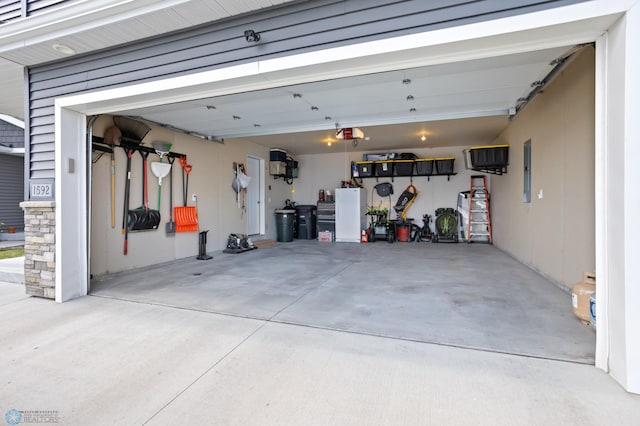 1592 69th Ave S, Fargo, ND 58104 - garage featuring electric panel, concrete driveway, and a garage door opener