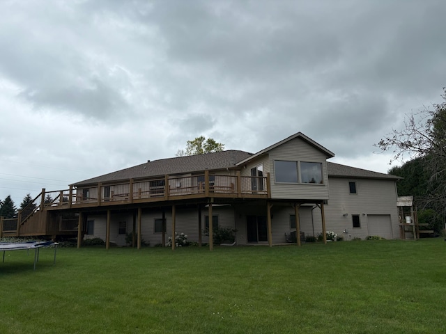 53030 254th Ave, Plainview Twp, MN 55964 - back of property with a trampoline, a lawn, a wooden deck, roof with shingles, and a garage