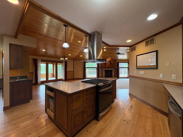 53030 254th Ave, Plainview Twp, MN 55964 - kitchen with gas range, island exhaust hood, a brick fireplace, a ceiling fan, and open floor plan