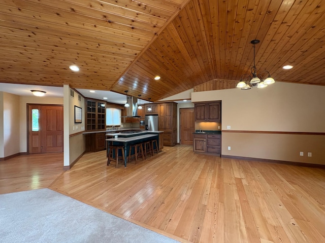 53030 254th Ave, Plainview Twp, MN 55964 - kitchen featuring exhaust hood, stainless steel fridge, light wood finished floors, a breakfast bar area, and vaulted ceiling