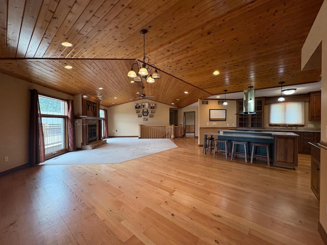 53030 254th Ave, Plainview Twp, MN 55964 - unfurnished living room featuring wooden ceiling, vaulted ceiling, a chandelier, light wood finished floors, and a fireplace with raised hearth