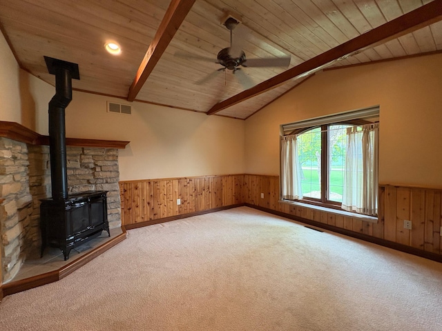53030 254th Ave, Plainview Twp, MN 55964 - unfurnished living room featuring wainscoting, wood ceiling, carpet flooring, a wood stove, and wooden walls
