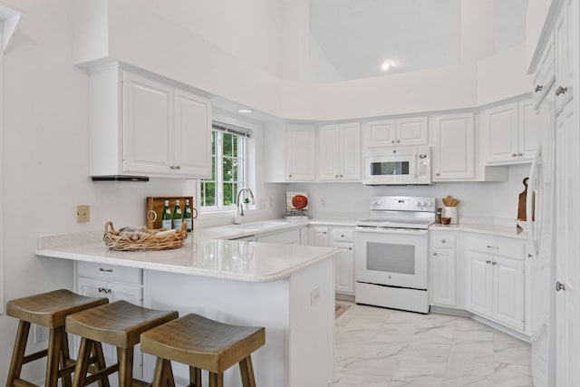 3725 Archer Ln N, Plymouth, MN 55446 - kitchen featuring white appliances, a peninsula, light marble finish floors, a kitchen bar, and white cabinets