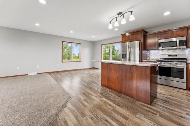 55170 Forest Blvd, Rush City, MN 55069 - kitchen with appliances with stainless steel finishes, light wood-style flooring, decorative backsplash, recessed lighting, and open floor plan