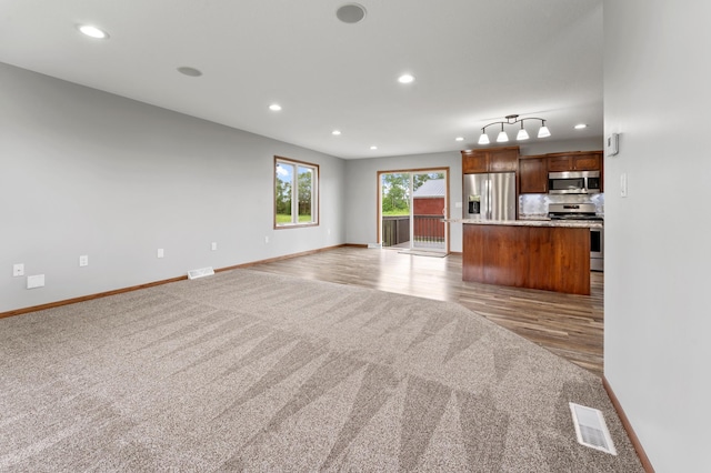 55170 Forest Blvd, Rush City, MN 55069 - unfurnished living room featuring light colored carpet, recessed lighting, and light wood finished floors