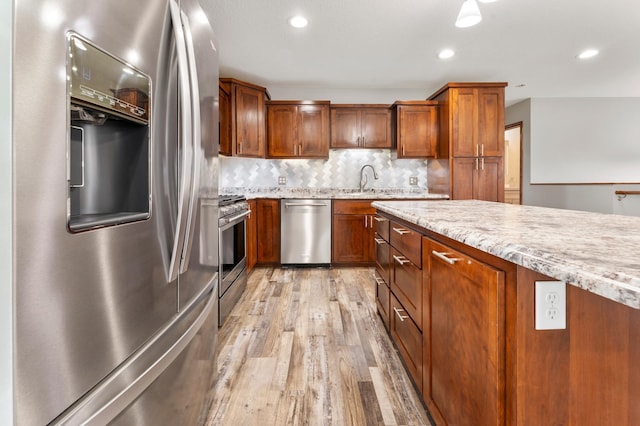 55170 Forest Blvd, Rush City, MN 55069 - kitchen with appliances with stainless steel finishes, light wood finished floors, tasteful backsplash, brown cabinets, and recessed lighting