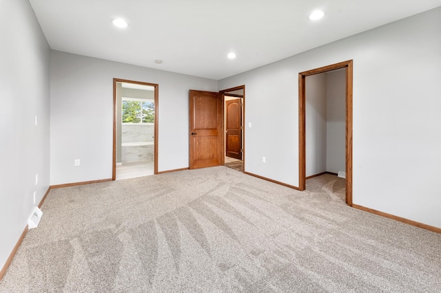 55170 Forest Blvd, Rush City, MN 55069 - unfurnished bedroom with a walk in closet, light carpet, recessed lighting, and ensuite bath