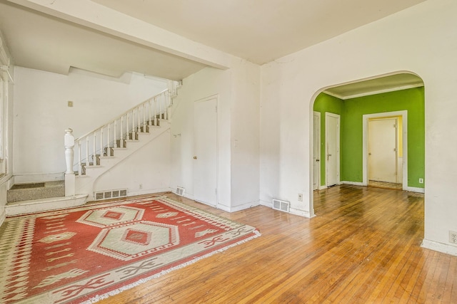 1111 Como Pl, Saint Paul, MN 55103 - empty room with arched walkways, wood-type flooring, and stairway