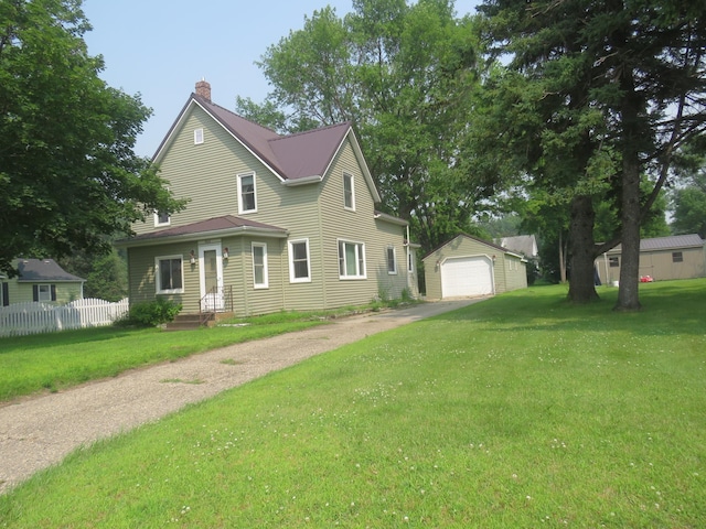 904 12th St N, Benson, MN 56215 - view of front of house with driveway, an outdoor structure, a detached garage, and a chimney