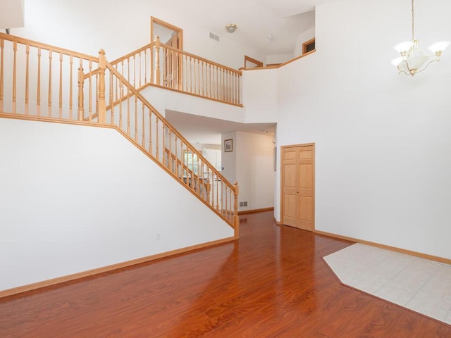 17625 48th Pl N, Plymouth, MN 55446 - unfurnished living room with wood finished floors, a chandelier, stairs, and a high ceiling