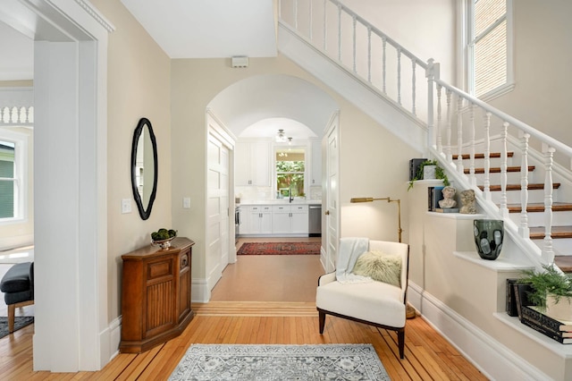 2636 Harriet Ave, Minneapolis, MN 55408 - foyer entrance with light wood-style floors, stairs, and arched walkways