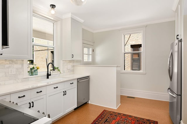 2636 Harriet Ave, Minneapolis, MN 55408 - kitchen with stainless steel appliances, backsplash, white cabinets, ornamental molding, and light stone countertops