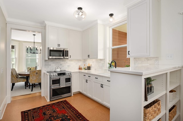 2636 Harriet Ave, Minneapolis, MN 55408 - kitchen featuring stainless steel appliances, a chandelier, tasteful backsplash, white cabinetry, and ornamental molding