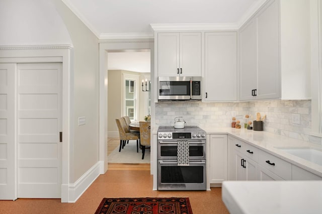 2636 Harriet Ave, Minneapolis, MN 55408 - kitchen with stainless steel appliances, decorative backsplash, light countertops, white cabinetry, and ornamental molding