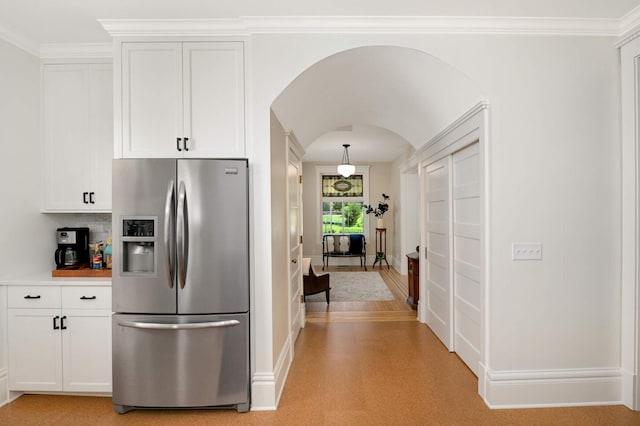 2636 Harriet Ave, Minneapolis, MN 55408 - kitchen with stainless steel refrigerator with ice dispenser, arched walkways, white cabinets, ornamental molding, and backsplash
