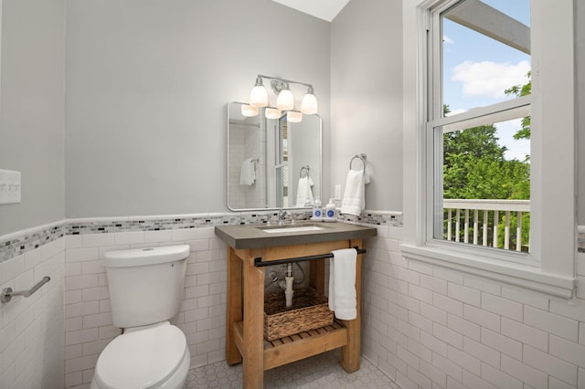 2636 Harriet Ave, Minneapolis, MN 55408 - bathroom with tile walls, a wainscoted wall, and tile patterned floors
