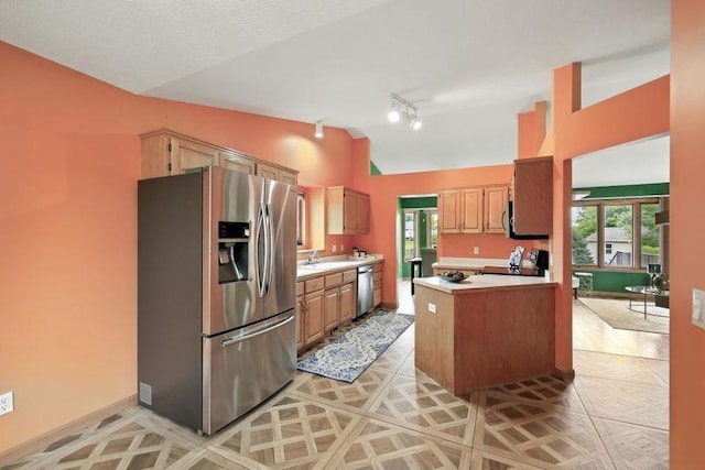 10374 61st St NE, Albertville, MN 55301 - kitchen featuring stainless steel appliances, vaulted ceiling, light countertops, track lighting, and a peninsula