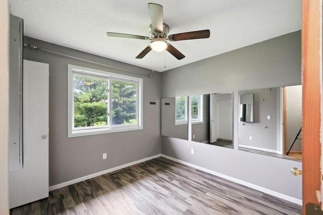 10374 61st St NE, Albertville, MN 55301 - unfurnished bedroom featuring wood finished floors, a ceiling fan, and a closet