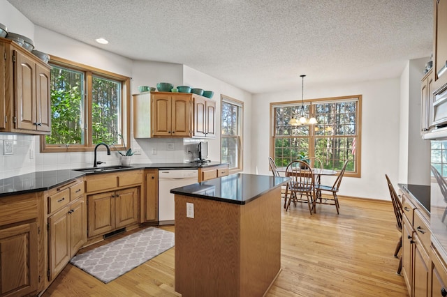 11691 115th St N, Grant, MN 55082 - kitchen featuring dishwasher, a textured ceiling, a center island, backsplash, and light wood-style floors