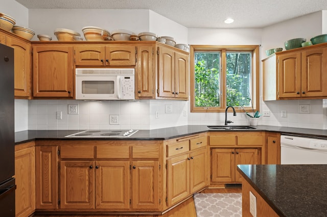 11691 115th St N, Grant, MN 55082 - kitchen featuring white appliances, a textured ceiling, light wood-style floors, decorative backsplash, and dark stone counters