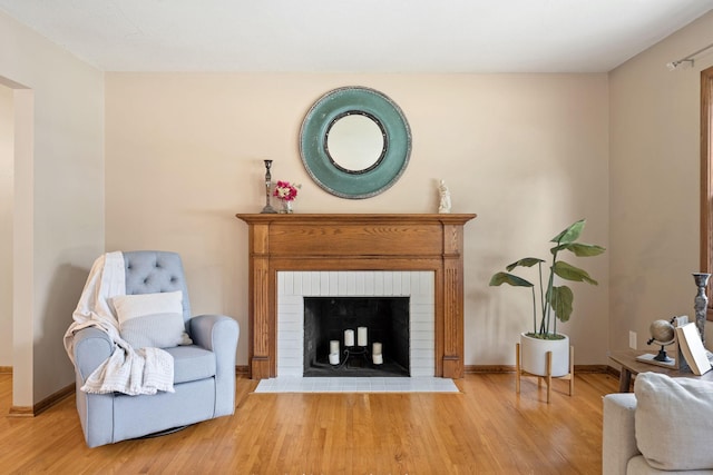 1762 Canyon Ln, New Brighton, MN 55112 - sitting room featuring wood finished floors and a brick fireplace