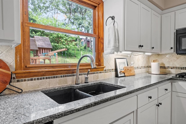 1762 Canyon Ln, New Brighton, MN 55112 - kitchen featuring black microwave, white cabinetry, decorative backsplash, and stone counters