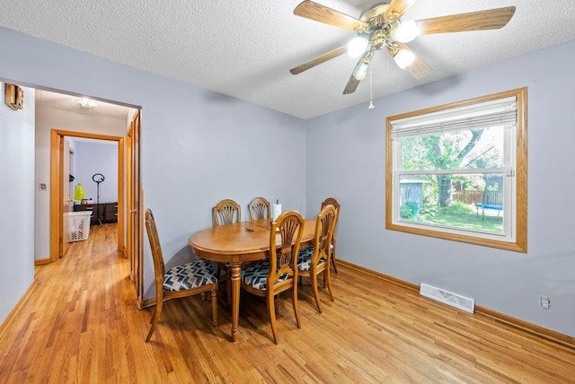 2813 Ohenry Rd, Brooklyn Center, MN 55430 - dining room featuring light wood-style flooring, a textured ceiling, and a ceiling fan