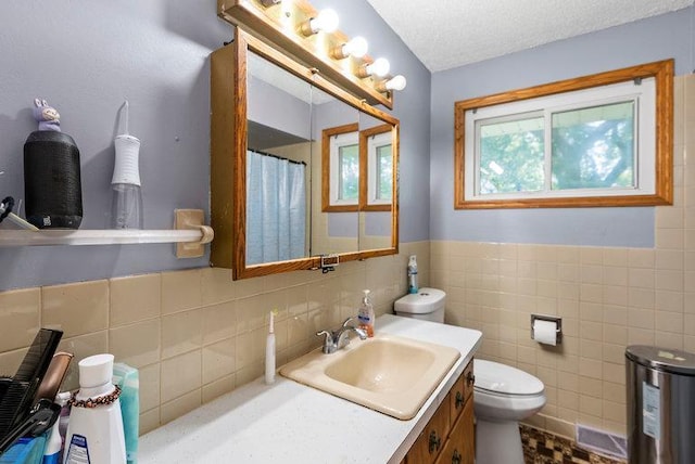 2813 Ohenry Rd, Brooklyn Center, MN 55430 - bathroom featuring tile walls, vanity, curtained shower, and a wainscoted wall