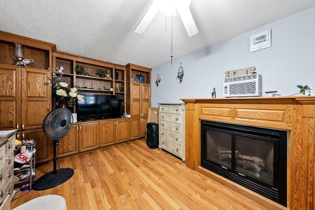 2813 Ohenry Rd, Brooklyn Center, MN 55430 - living area with a ceiling fan, a glass covered fireplace, light wood-style floors, and a textured ceiling