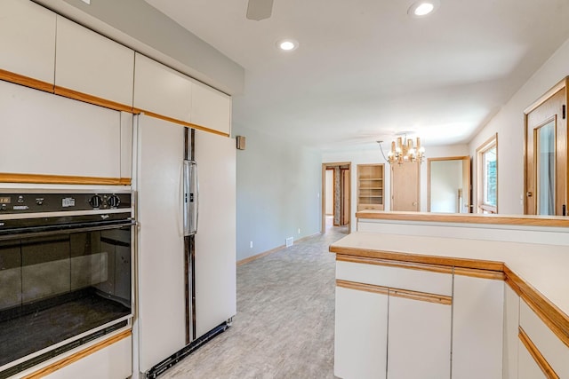 3330 Belden Dr NE, Saint Anthony, MN 55418 - kitchen with black oven, a chandelier, white cabinetry, recessed lighting, and light countertops