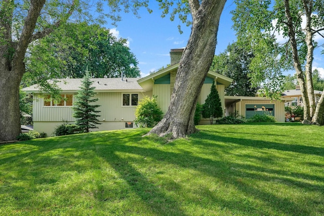 3330 Belden Dr NE, Saint Anthony, MN 55418 - back of property with a chimney, a yard, and an attached garage
