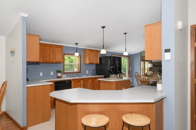 4179 W Tischer Rd, Rice Lake, MN 55803 - kitchen featuring black appliances, a center island, brown cabinetry, healthy amount of natural light, and a textured ceiling