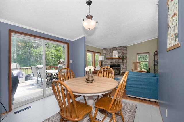 4179 W Tischer Rd, Rice Lake, MN 55803 - dining space featuring a textured ceiling, ornamental molding, light flooring, a stone fireplace, and vaulted ceiling