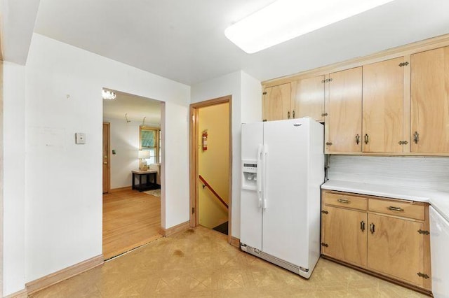 7501 Elliot Ave S, Richfield, MN 55423 - kitchen with white fridge with ice dispenser, light countertops, decorative backsplash, light flooring, and light brown cabinetry