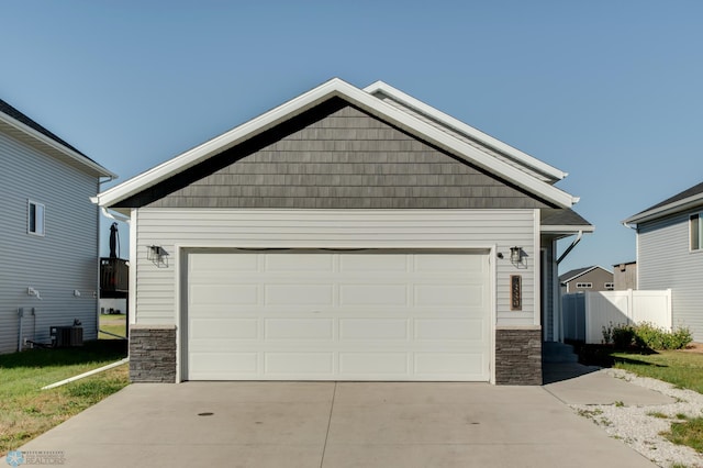 7339 24th St S, Fargo, ND 58104 - view of front of property featuring stone siding, a garage, and driveway