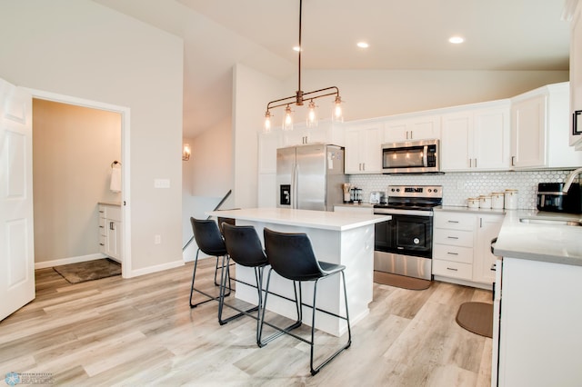 7339 24th St S, Fargo, ND 58104 - kitchen with stainless steel appliances, a breakfast bar area, backsplash, white cabinets, and recessed lighting