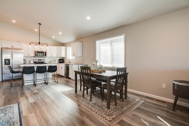 7339 24th St S, Fargo, ND 58104 - dining room with vaulted ceiling, wood finished floors, and recessed lighting