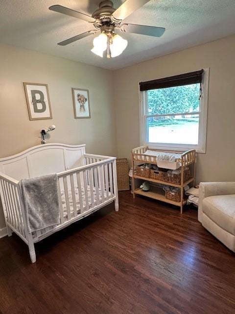5025 Wilshire Blvd, Crystal, MN 55429 - bedroom featuring wood finished floors, ceiling fan, a crib, and a textured ceiling