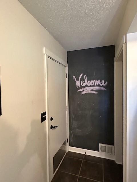 5025 Wilshire Blvd, Crystal, MN 55429 - entryway featuring dark tile patterned flooring and a textured ceiling
