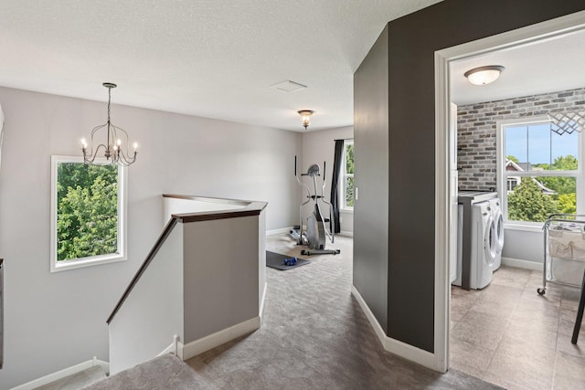 6287 Fountain Ln N, Maple Grove, MN 55311 - hall with an upstairs landing, washer / dryer, plenty of natural light, a chandelier, and a textured ceiling