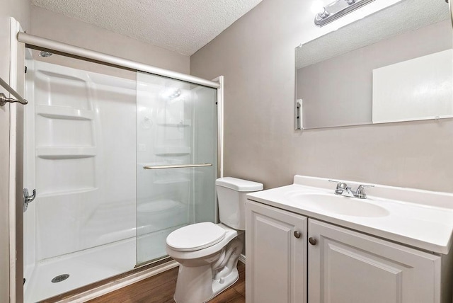 7248 72nd Ln N, Brooklyn Park, MN 55428 - bathroom featuring a textured ceiling, a shower stall, vanity, and wood finished floors