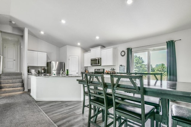 39604 Fallbrook Ave, North Branch, MN 55056 - dining room featuring light wood-style flooring, lofted ceiling, recessed lighting, and stairway
