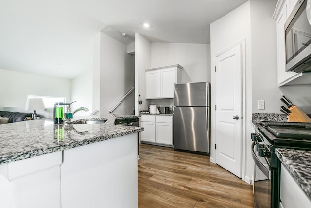 39604 Fallbrook Ave, North Branch, MN 55056 - kitchen featuring appliances with stainless steel finishes, stone counters, white cabinets, wood finished floors, and open floor plan