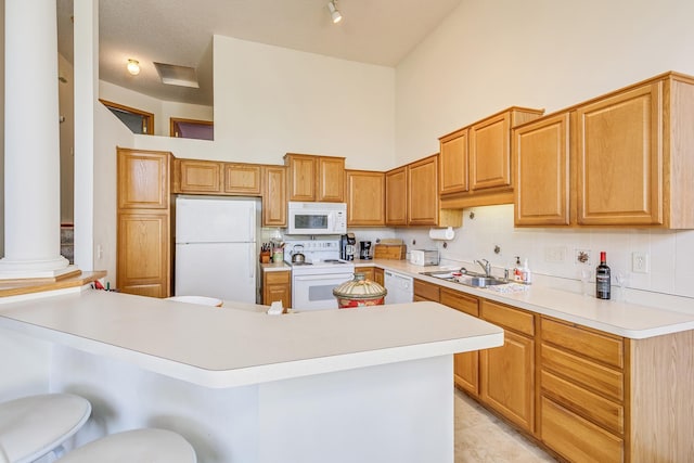 15126 Cimarron Way, Rosemount, MN 55068 - kitchen with white appliances, light countertops, decorative columns, a peninsula, and decorative backsplash