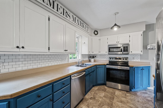7635 165th Ave NE, Columbus, MN 55025 - kitchen with stainless steel appliances, blue cabinets, white cabinets, tasteful backsplash, and light countertops