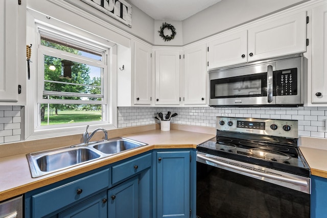 7635 165th Ave NE, Columbus, MN 55025 - kitchen featuring stainless steel appliances, blue cabinets, light countertops, and white cabinetry
