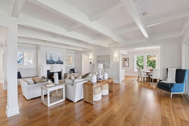 2462 Lafayette Rd, Minnetonka Beach, MN 55391 - living room featuring light wood finished floors, beam ceiling, coffered ceiling, a lit fireplace, and a chandelier